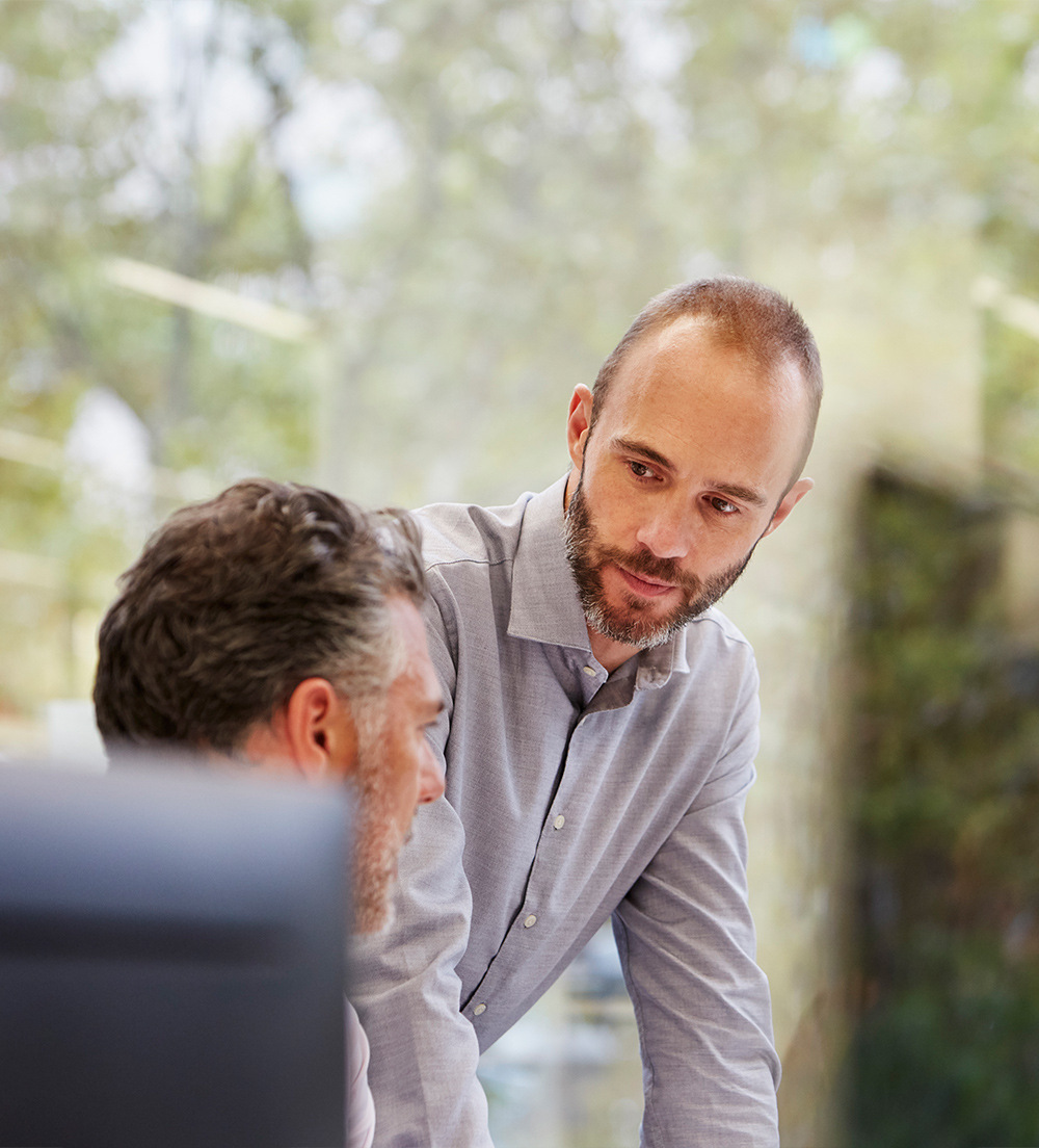 An office employee listens intently to his colleague.