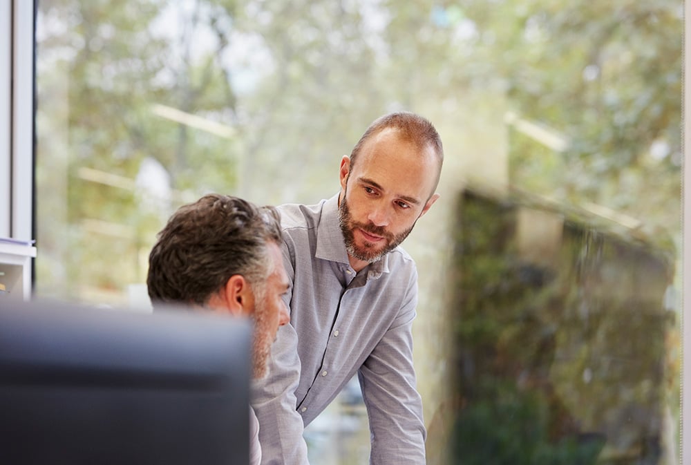 An office employee listens intently to his colleague.