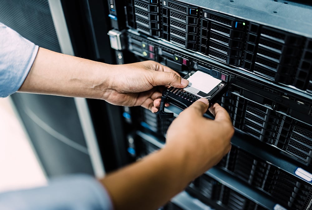 IT Manager entering a hard disk into the data center.